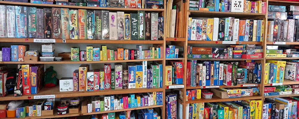 Centaines de jeux de sociétés rangés sur des étagères